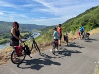 Mehrere Radfahrer machen eine Pause mit Aussicht auf das Moseltal