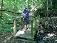 Wanderer auf dem Moselsteig mit kleiner Brücke